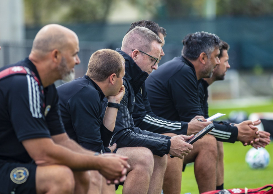 Football coaches using tablets during a training session
