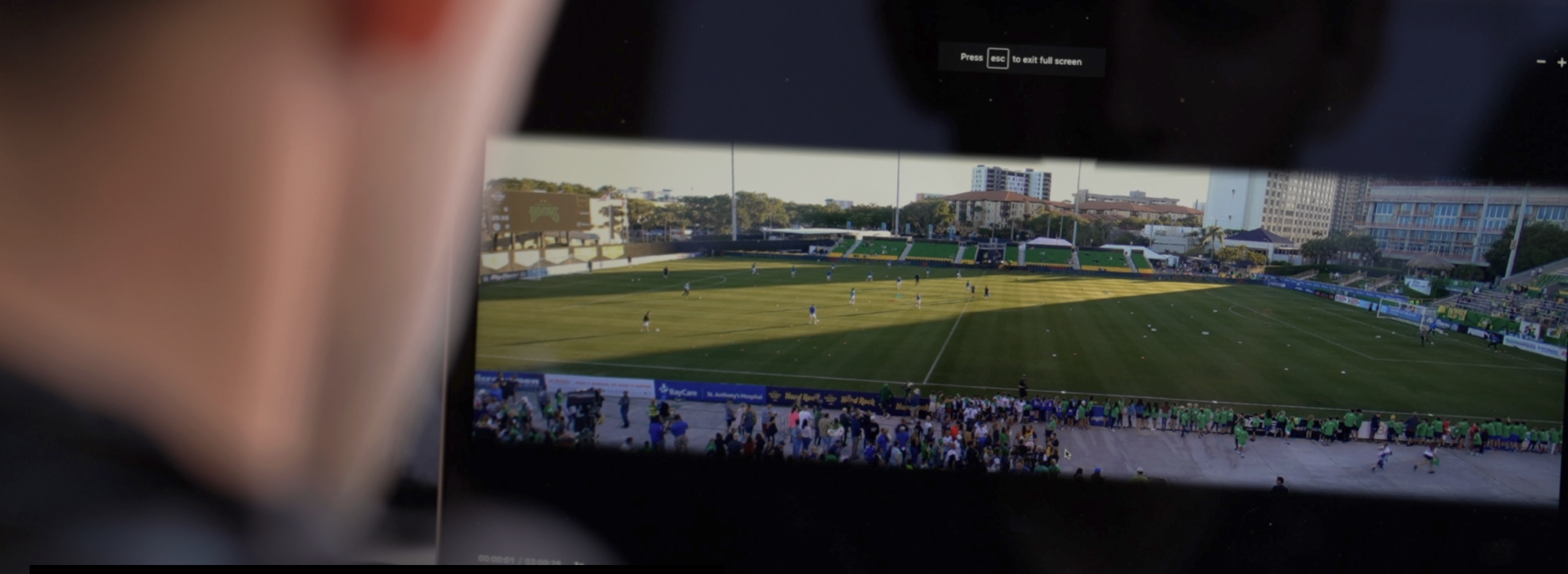 Coach reviewing a football pitch recording on a screen